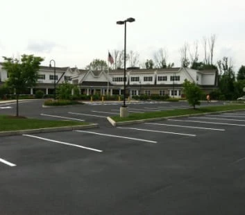 A parking lot in front of a large building.