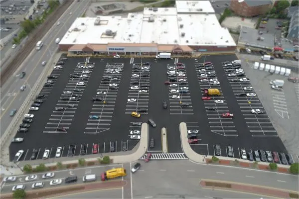 An aerial view of a parking lot with cars parked in it.